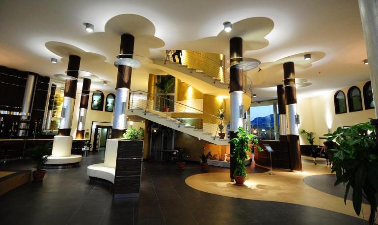 Elegante hall con colonne moderne e luce soffusa, atmosfera accogliente e raffinata.