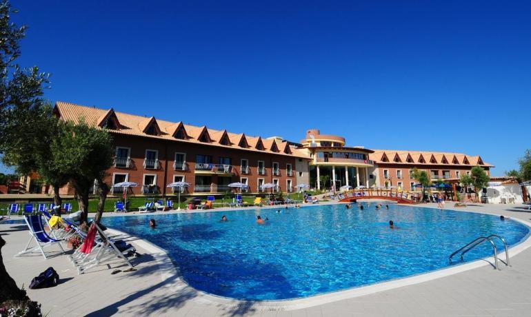 Hotel con piscina, cielo azzurro, atmosfera rilassante e vacanziera.