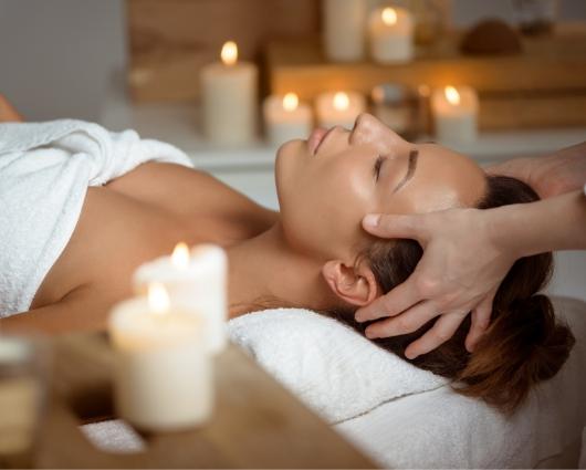 Rilassante massaggio alla testa in un ambiente con candele accese.